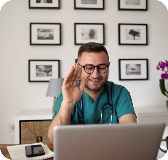 Una persona sentada en un escritorio con las manos en la cara