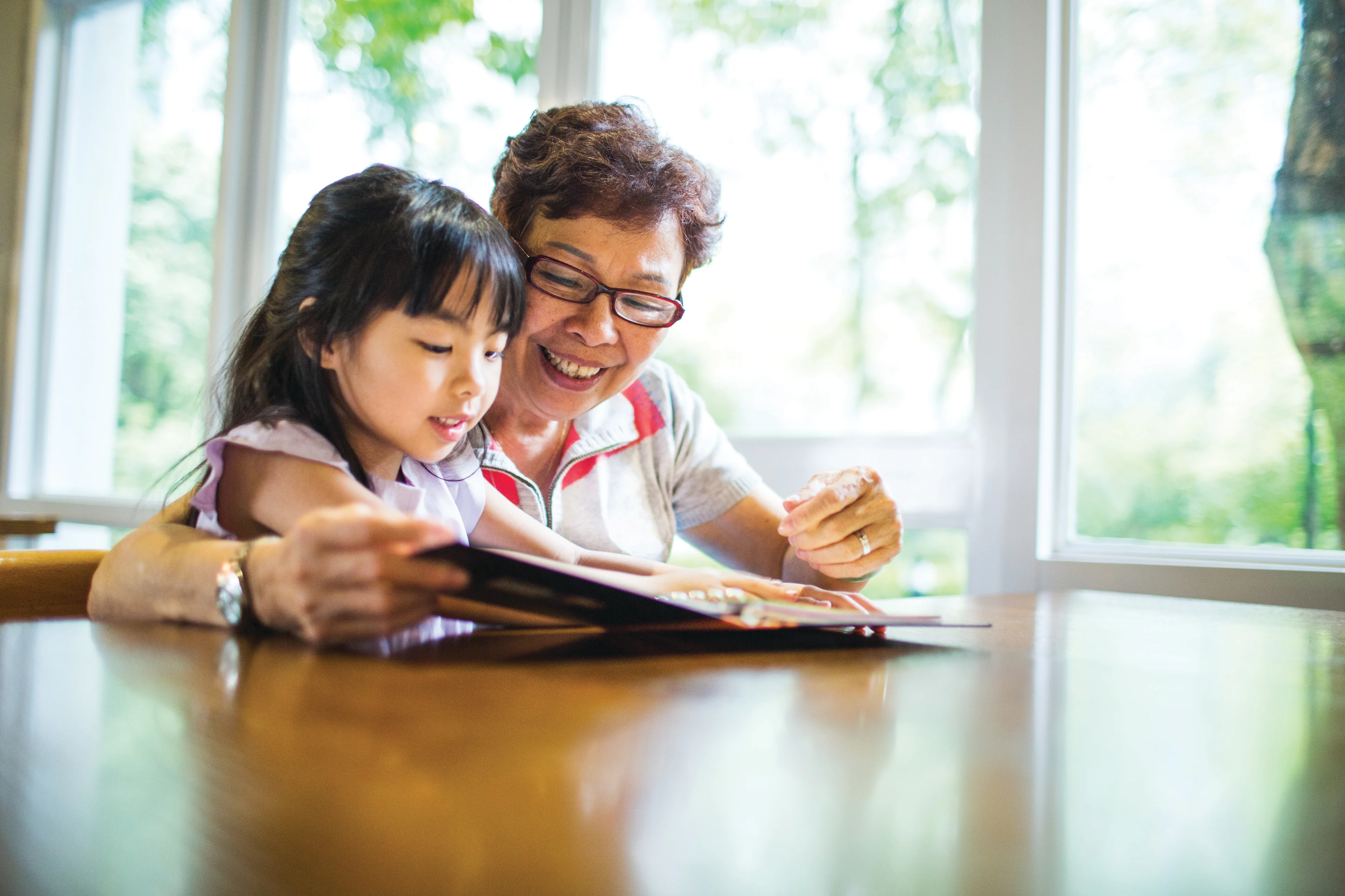 una mujer y una niña mirando un libro