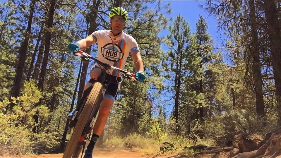 man living with an ostomy riding a bike outdoors 